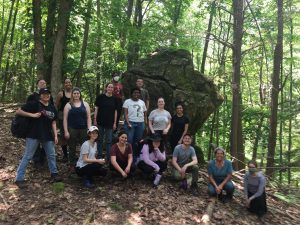 MSU archaeological field school students and staff in front of a large stone feature that is part of the Ramapough Lunaape Nation’s Ceremonial Stone Landscape. Turtle Clan mother Micheline Picaro is second from the right.