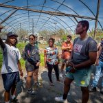 Christian Rodriguez, urban agriculture manager at Down Bottom Farms, leads Montclair students on a tour of the garden. Among the group, graduate students Leanna Sanchez ’22, second from left, and Krishna Polius, third from left, are part of the Anthropology class that explores solutions to building sustainable communities.