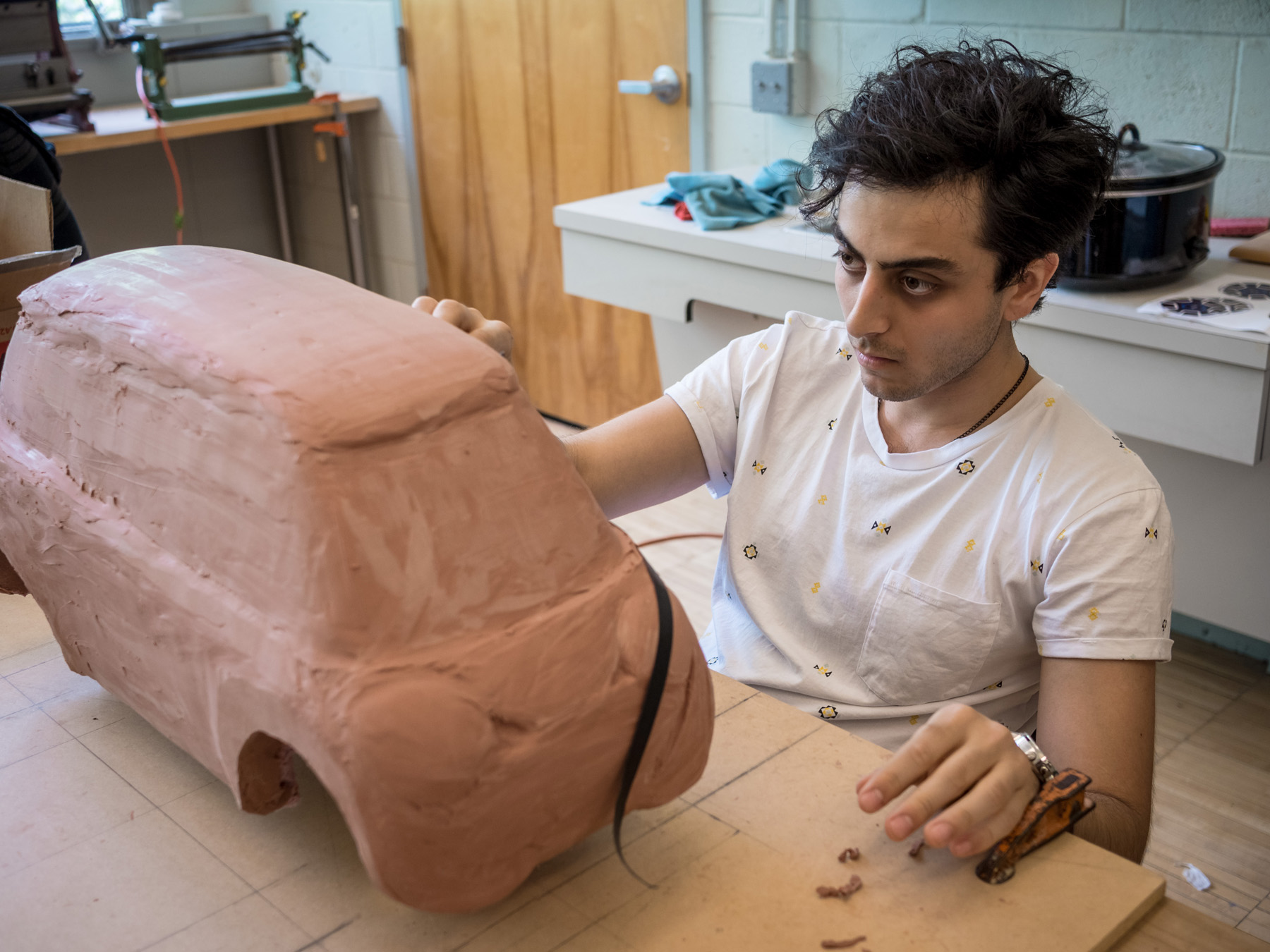 Khashayar Afshar works on a clay model of his electric car design.