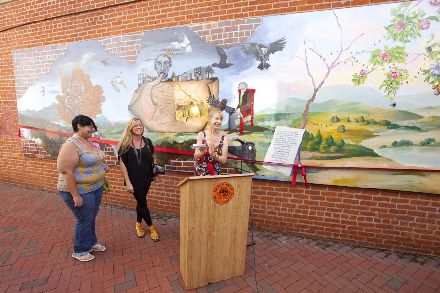 three women in front of mural