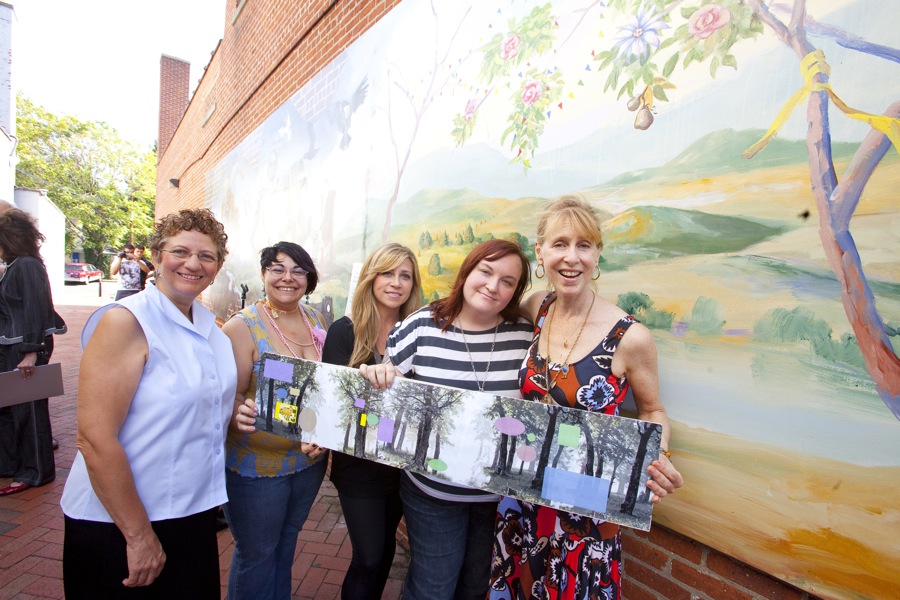 women in front of mural
