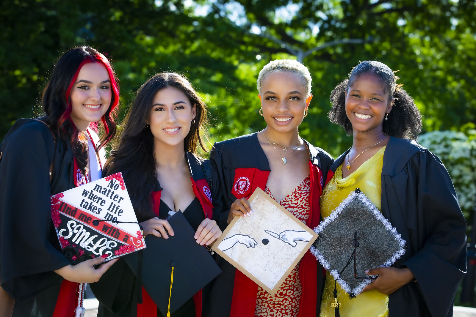 four young women posing with cap and gown