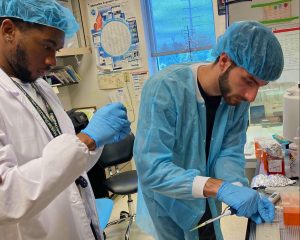 Charles Ezenwanne working with Zachary Bonelli in the lab