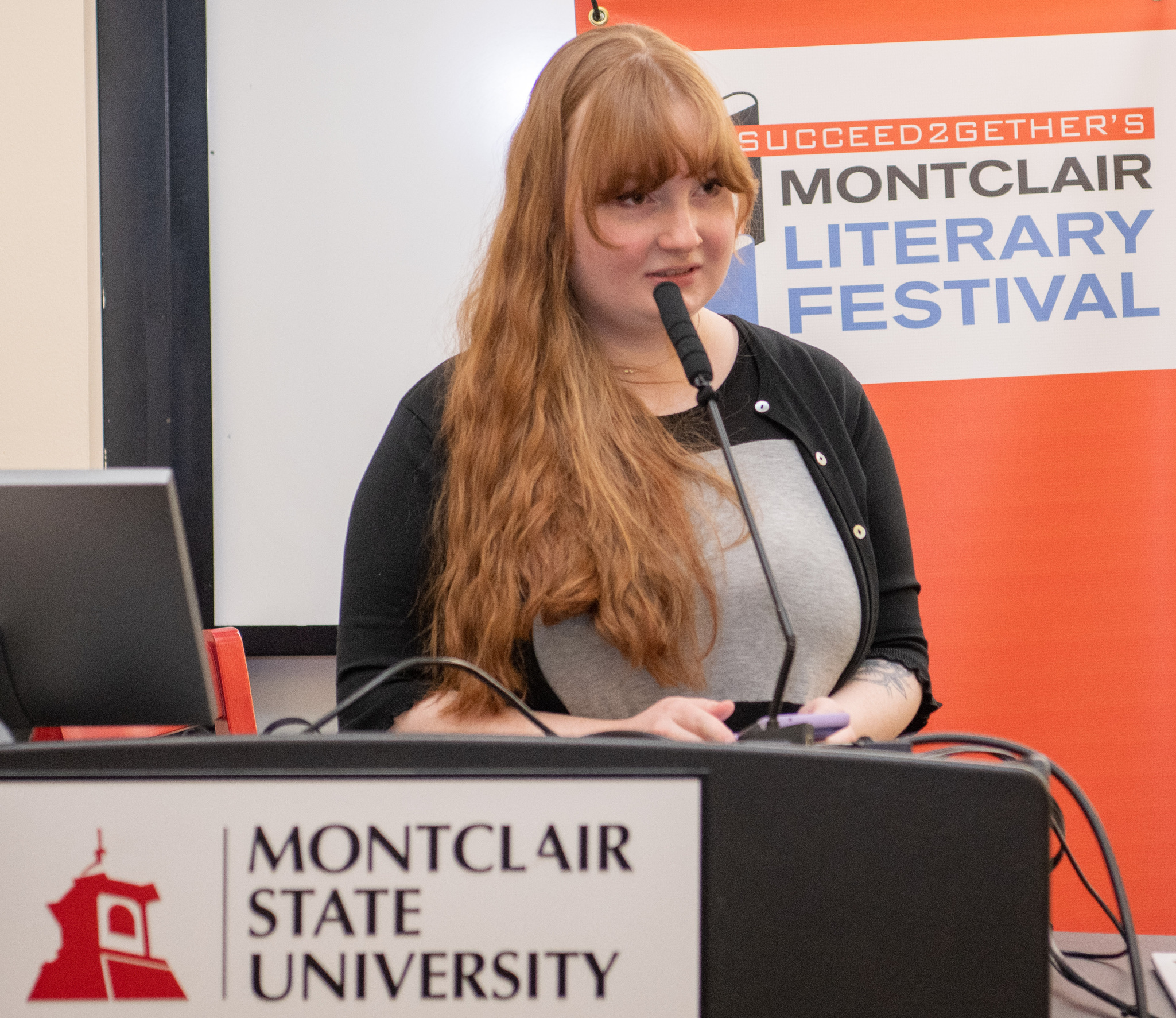 student Kaitlyn Alden speaking at a podium