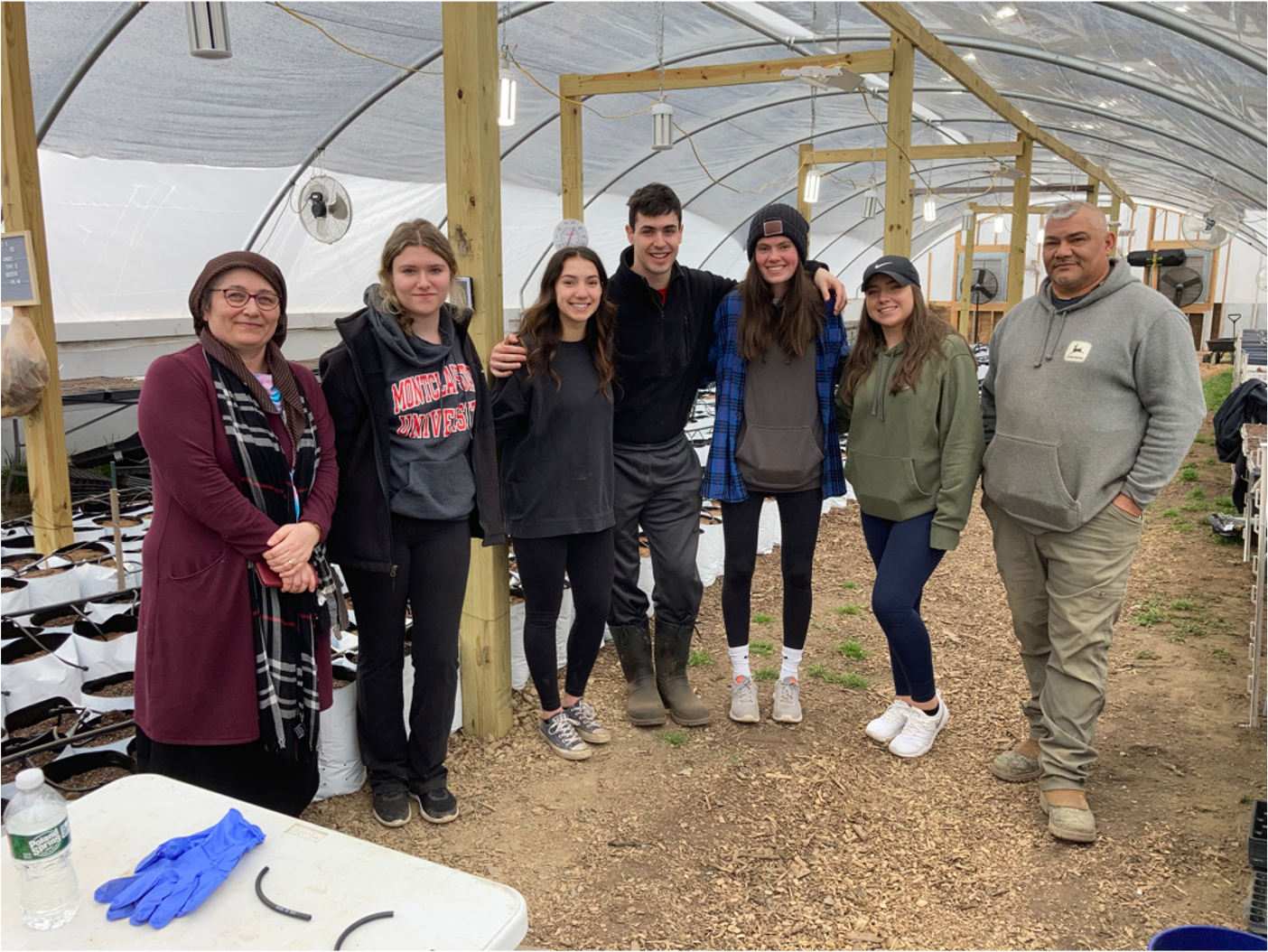 Students in the greenhouse of Munsee 3 Sisters Farm with Chief Vincent Mann (Spring 2022).png