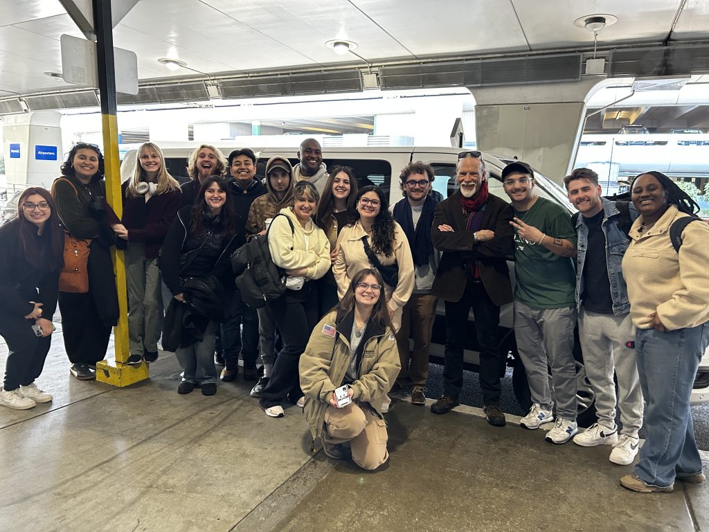 Group photo of all students at the airport for their spring break production trip.