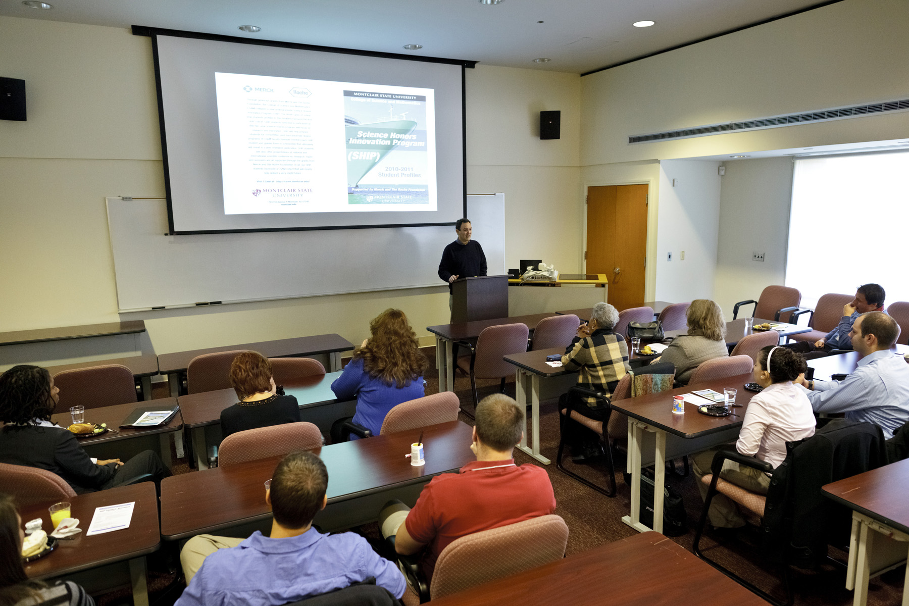 Representatives from Merck and Roche, and SHIP students listen to Yecko's presentation.