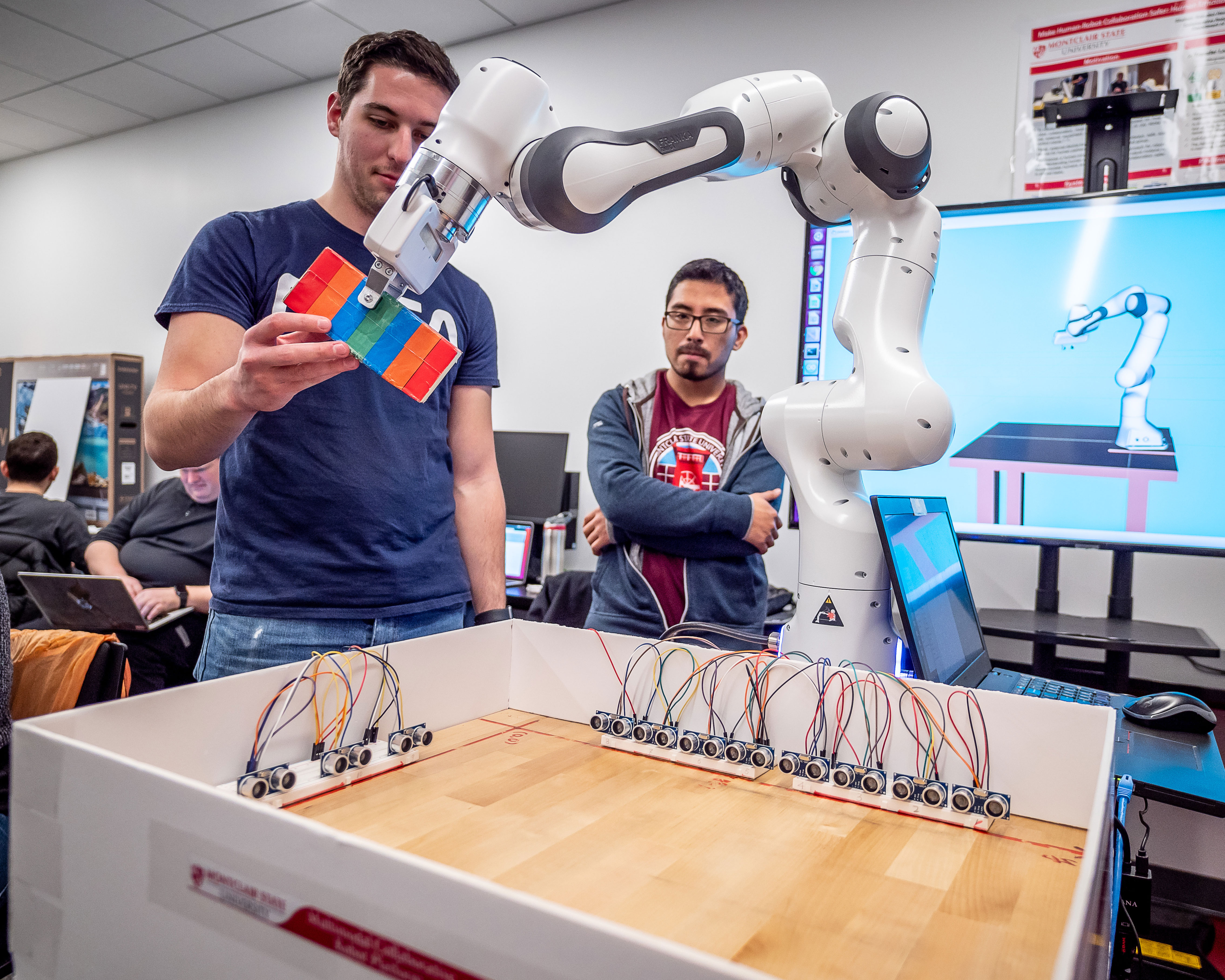 students working with robotic arm