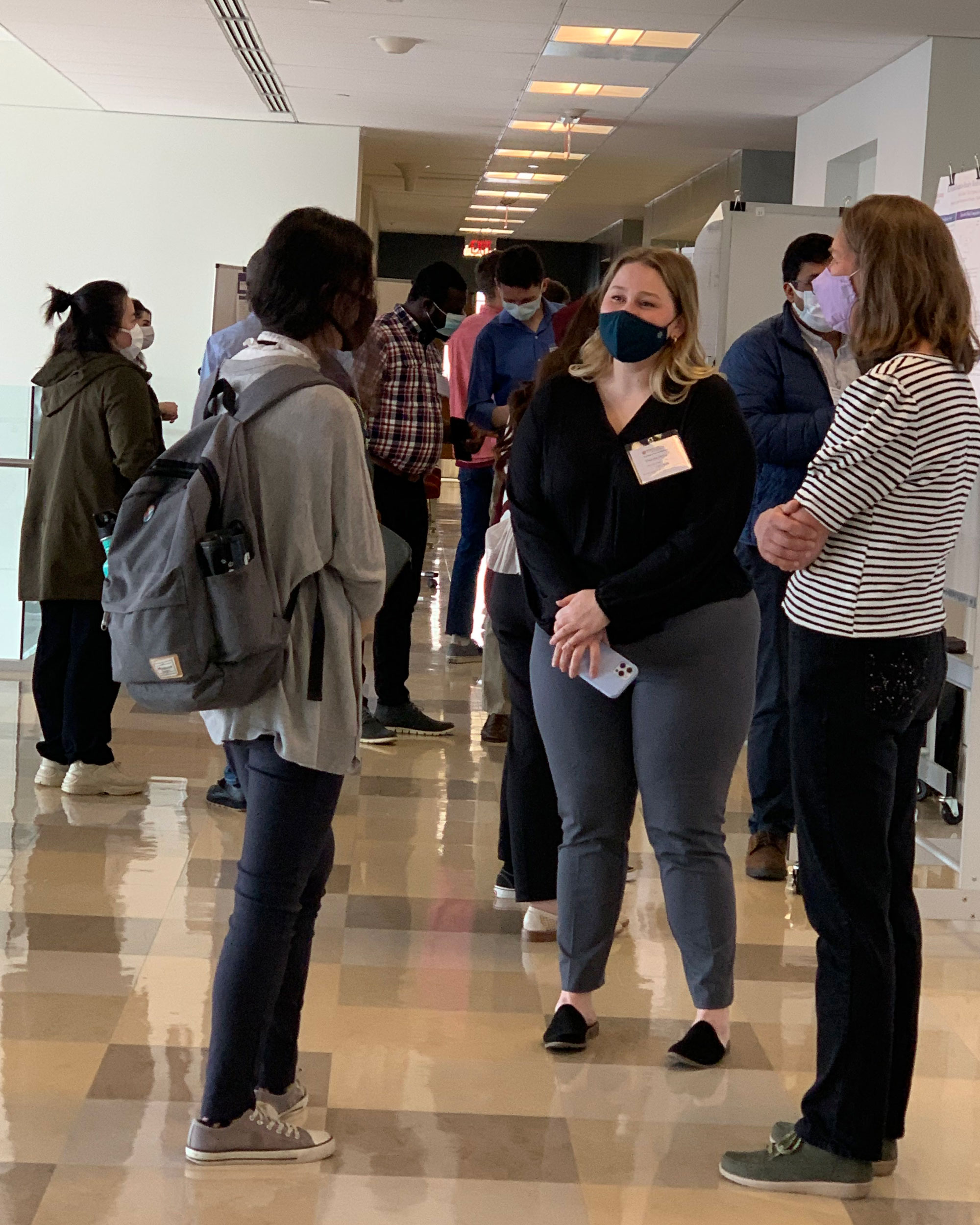 research group talking by poster