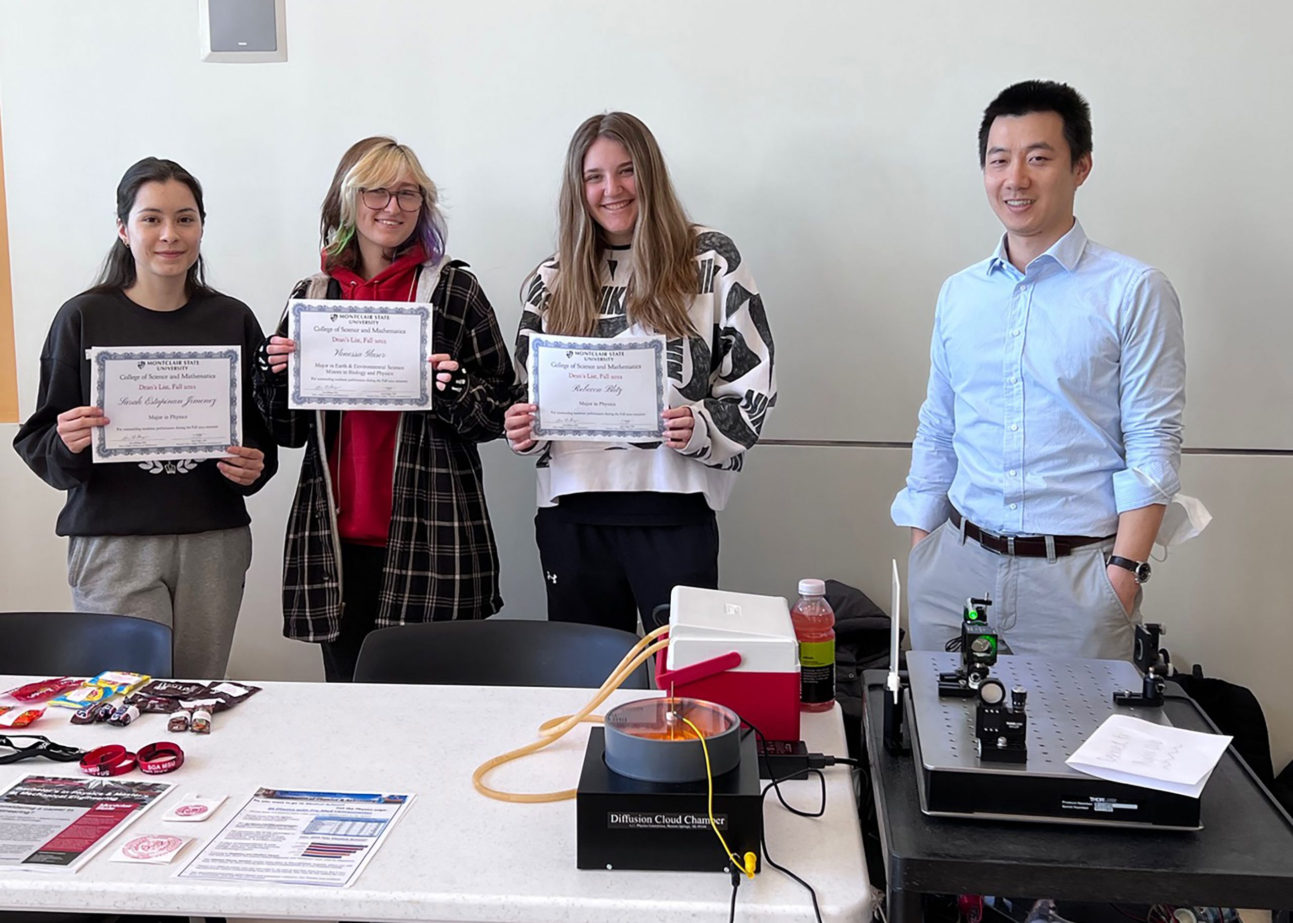 Physics Club table at STEM-Powerment org fair, students with Dean's List certificates