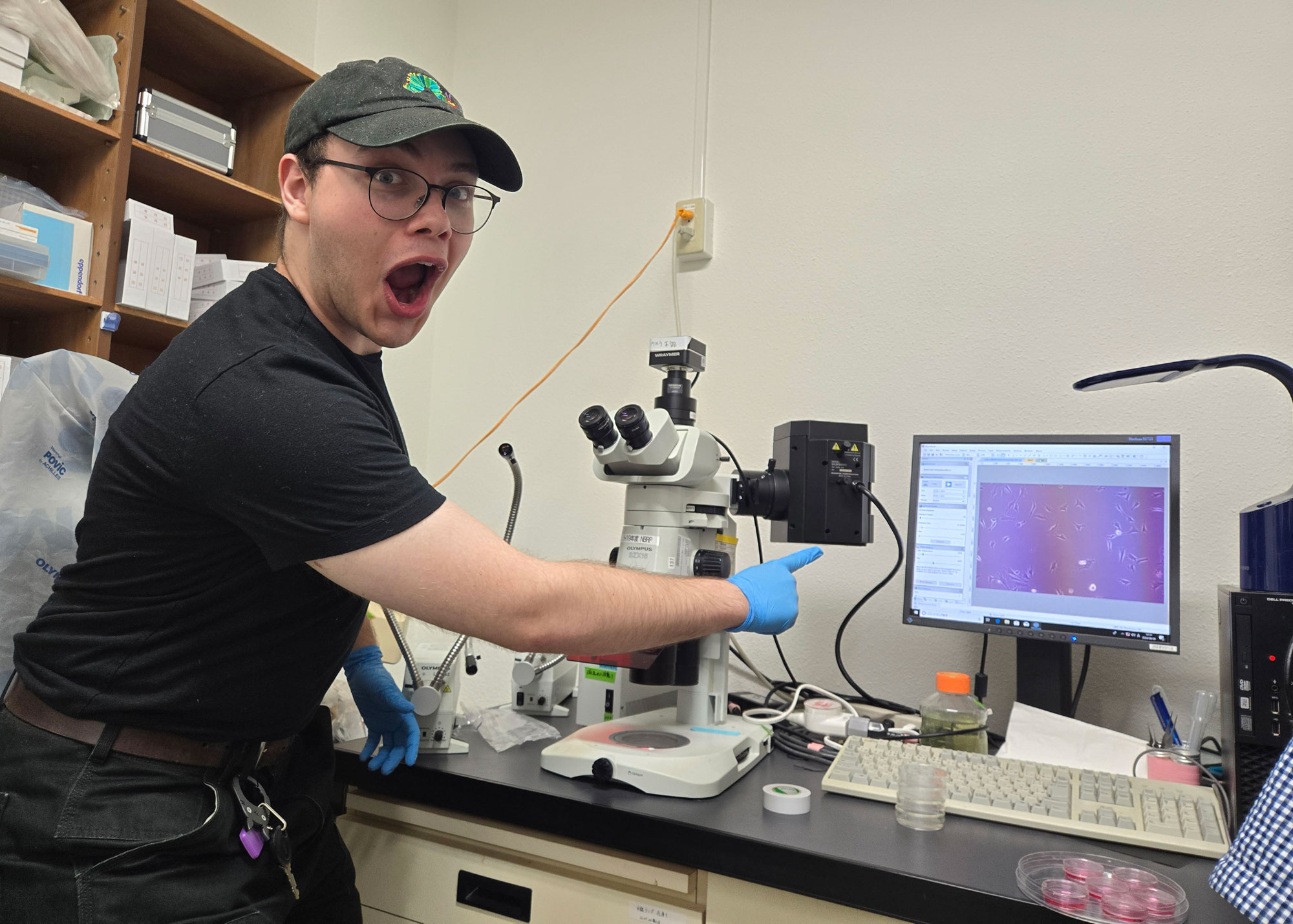student happy about finding with microscope
