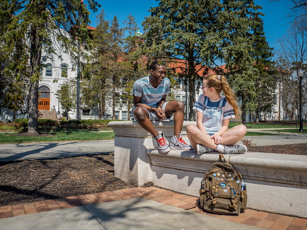 Students laughing together sitting outside of College Hall