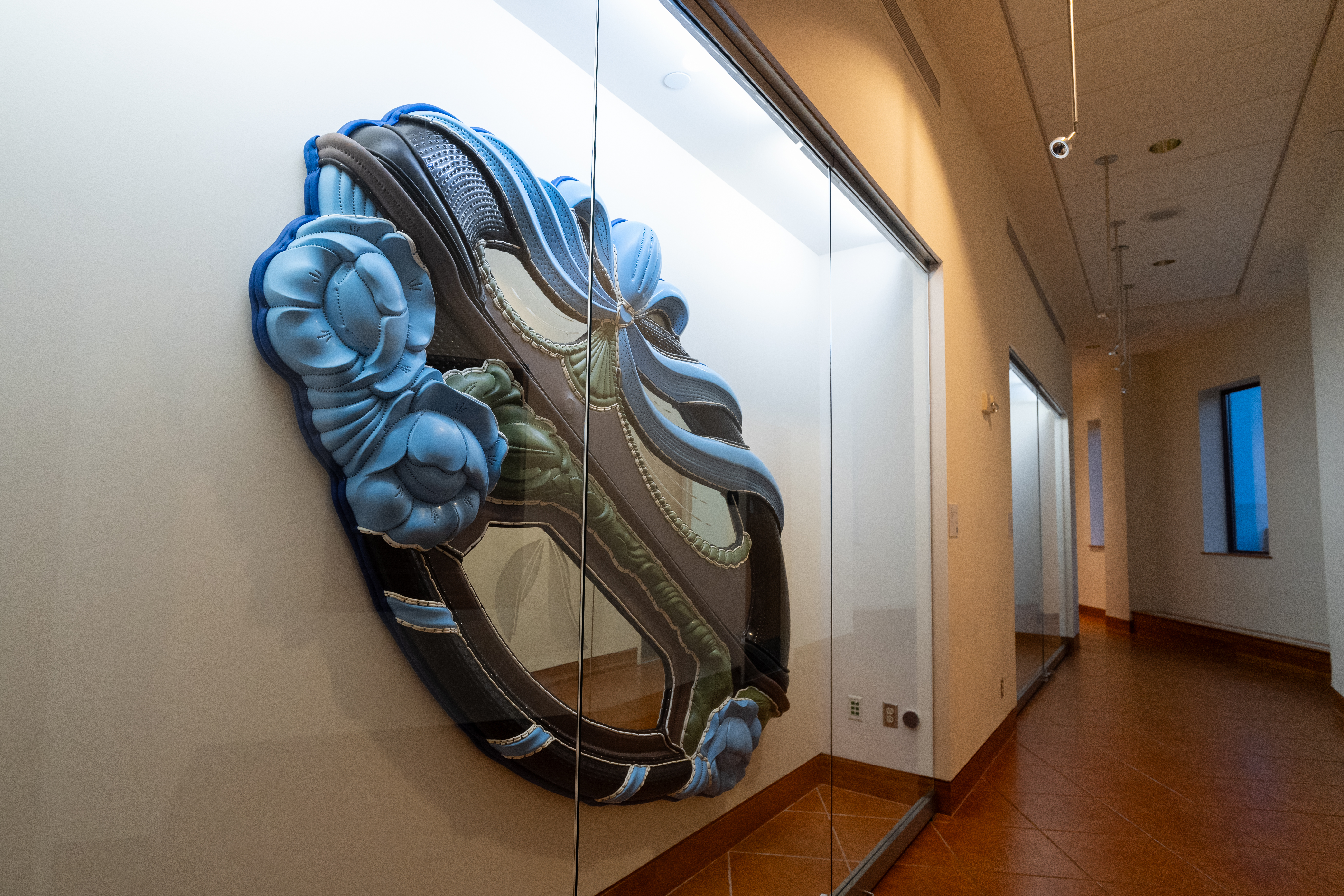 A large blue artwork behind a glass case.