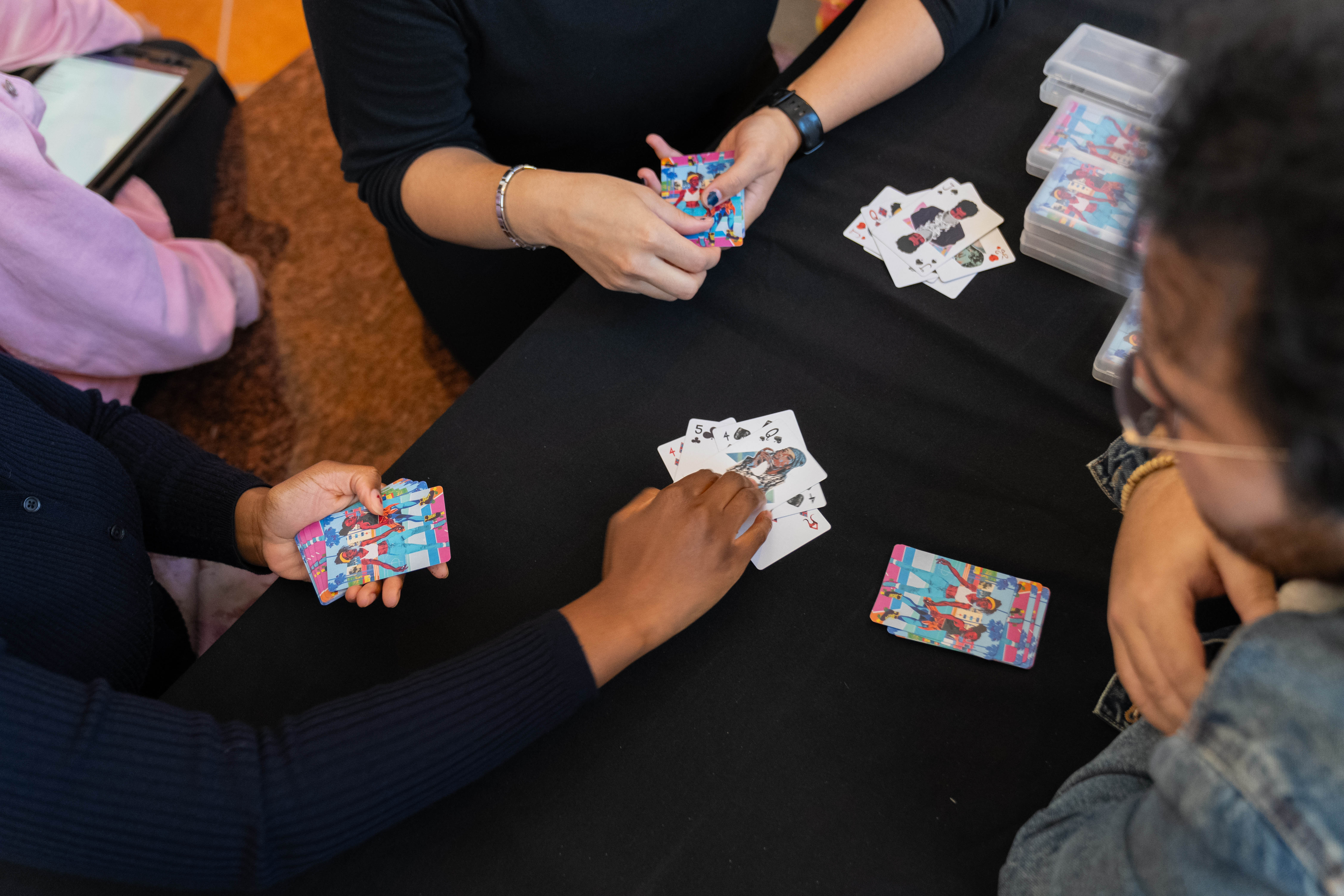 Students play a game of cards as part of a social engagement-based performance piece.