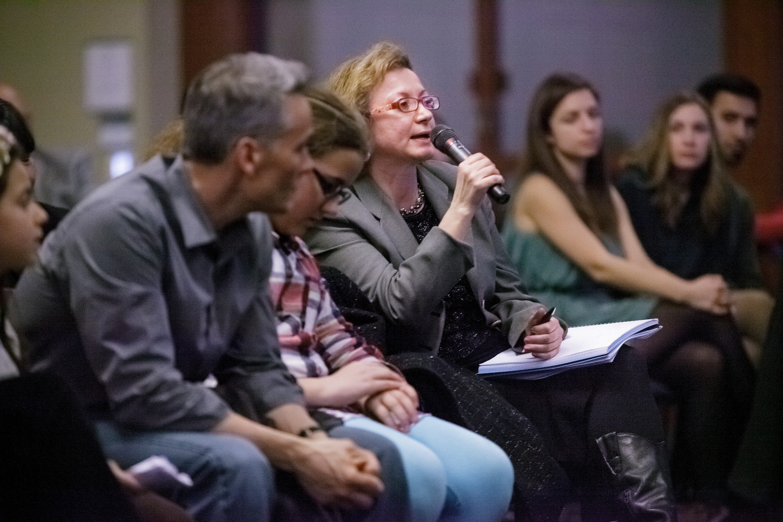 Woman in audience speaking into microphone