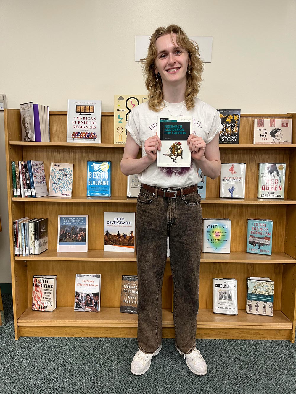 Andrew Linden holding the book Research and Design for Fashion