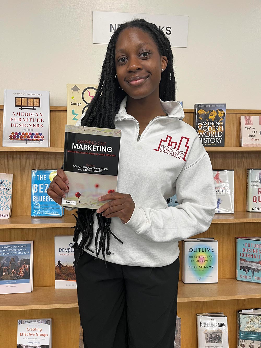 Arielle Touaboy holding the book Mapping out Marketing