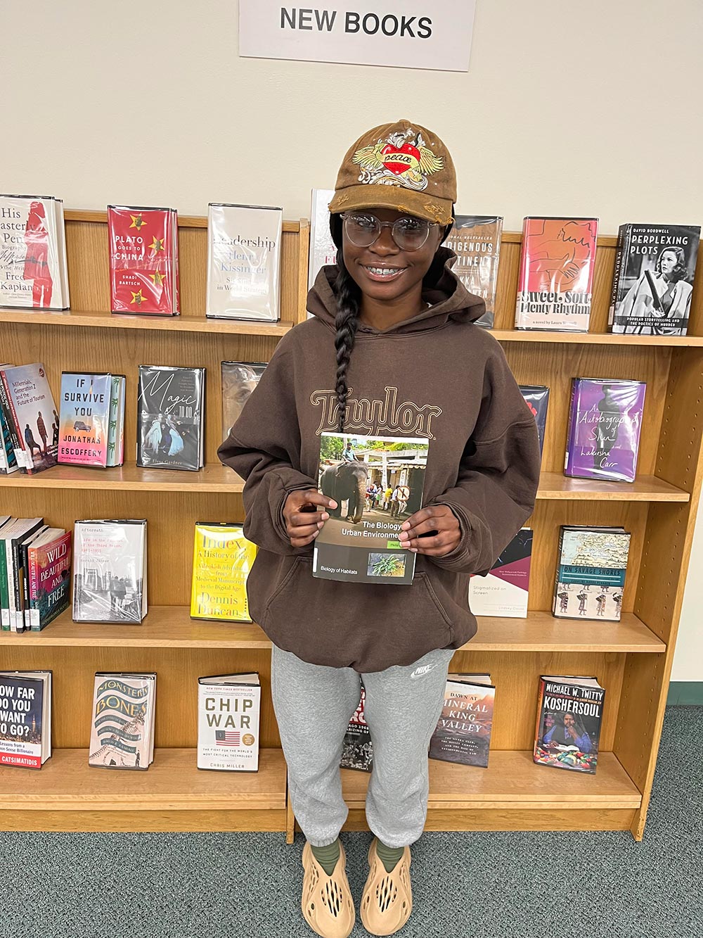 Bridget Osei holding the book The Biology of Urban Environments