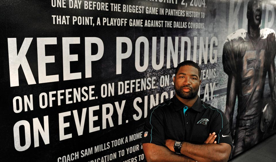 Photo of Sam Mills III in front of a mural.