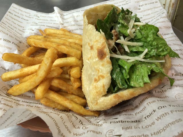 Photo of a flatbread sandwich and fries combo prepared at the Flatbread Grill.