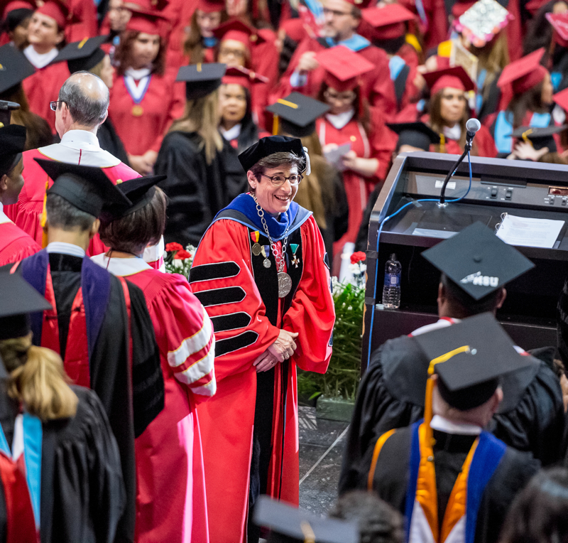 Dr. Susan A Cole, wearing graduation gown, smiling.