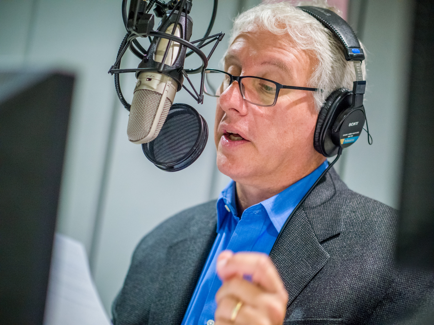 David Brancaccio speaking into microphone at Montclair State studios.