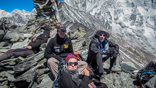 A trio of climbers resting on rocky crags in Puja.