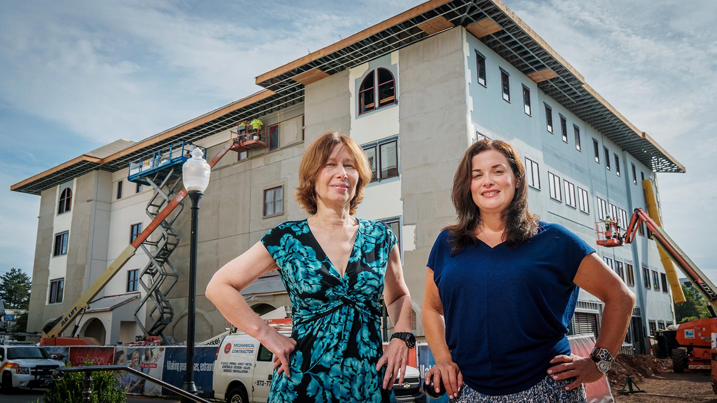 Dean Janice Smolowitz and Courtney Reinisch, director of Undergraduate Nursing, posing in front of construction site at Partridge Hall.