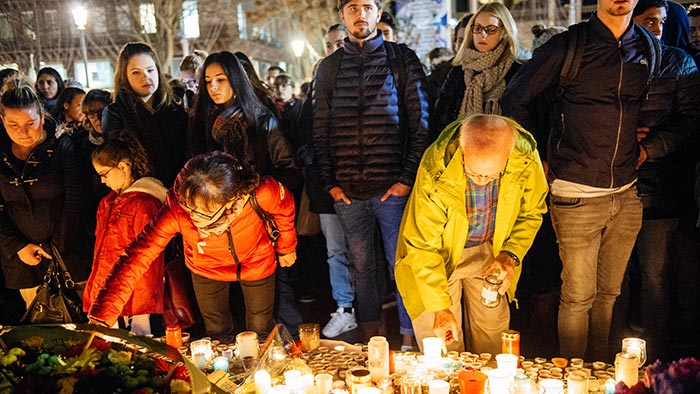 Mourners place candles at a memorial for victims of the 2015 Paris terror attacks.