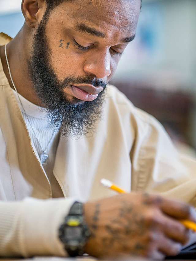 Inmate Edward Hawkins concentrates on a math problem.