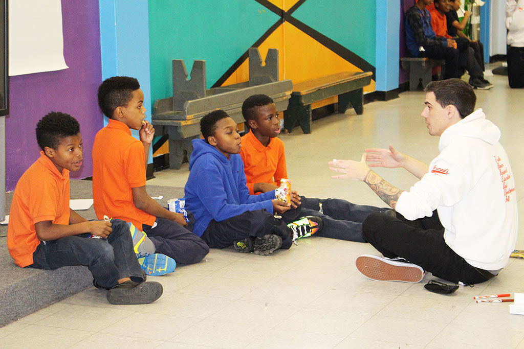 Kyle Boomhower sitting on floor with kids.