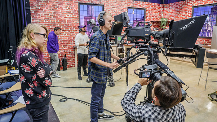 Students on set with film equipment in School of Communication and Media’s new media production facility.