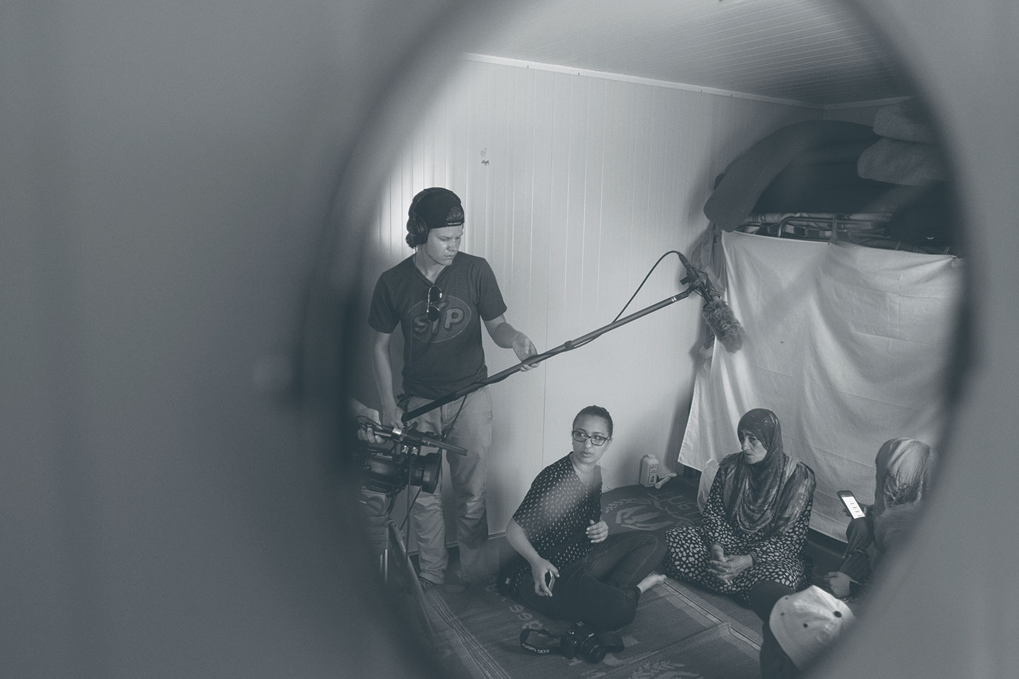 Students Shawn Latham and Nadia Abbas interview a refugee family from Syria inside the family’s trailer at the Kara Tepe camp in Lesbos.