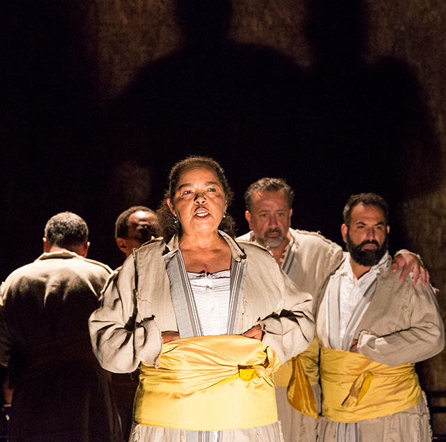 Lynda Gravatt (Shylock No. 3) delivers Shylock’s famous speech “Hath not a Jew eyes?” surrounded by, from left, Shylock No. 5 (Steven Skybell), Shylock No. 4 (Michael Rogers), Shylock No. 2 (Frank Rodriguez), and Shylock No. 1 (Sorab Wadia).