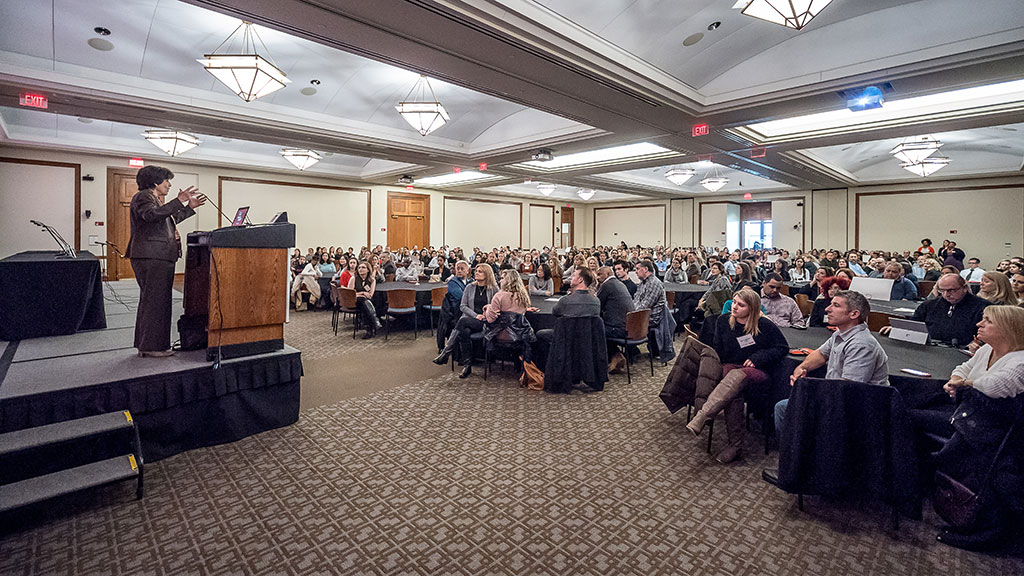 Susan A. Cole speaking from podium to Presidential Scholars.