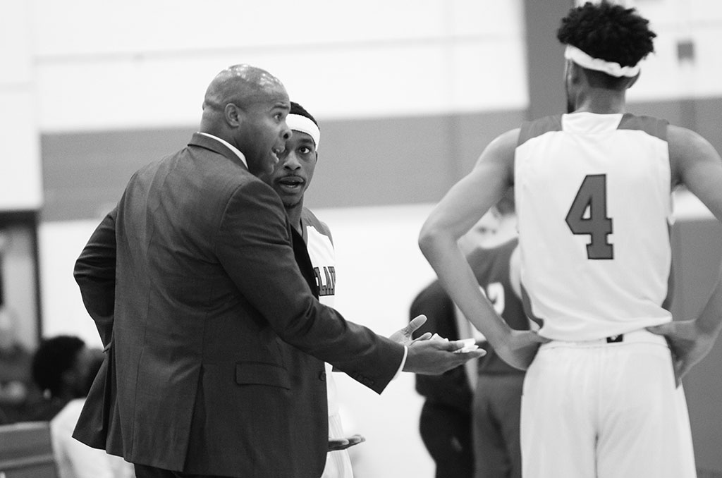 Coach Marlon Sears encourages players during a close game, prior to victory.