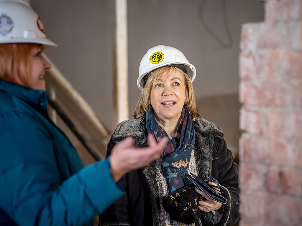 Lorraine Arnold ’11, a buildings archaeologist/genealogist, returned to her alma mater to see firsthand the College Hall renovations and to assist in the search for descendants of the bricklayers. She is shown with Sharon Mahoney, the University’s director of construction management.