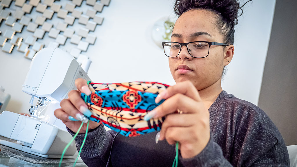 Awilda Quezada Puntiel puts the finishing touches on a handmade mask.