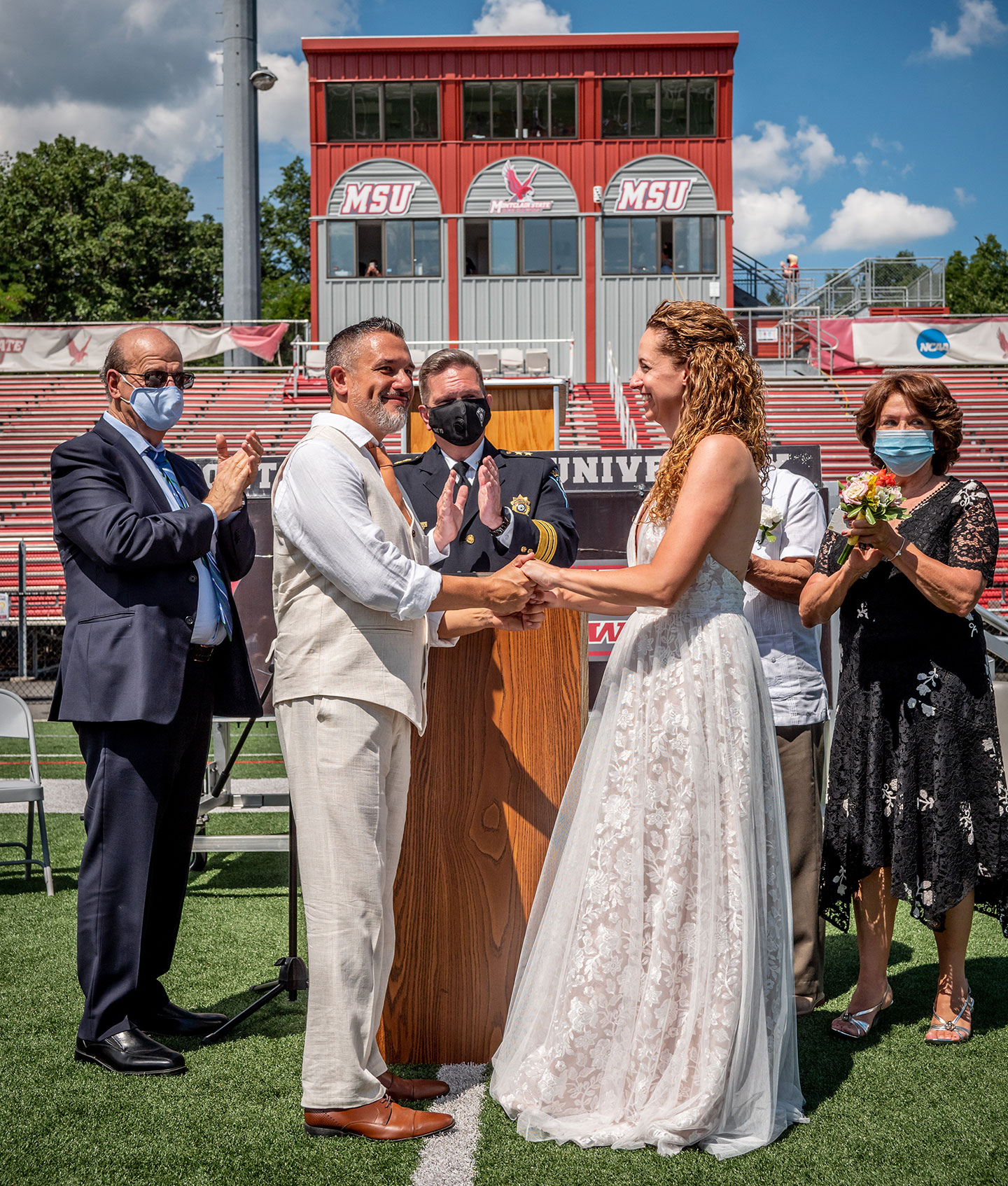 Chief of University Police Paul Cell officiates the wedding of Janet Fenner and Gregory Dabice on the Montclair State 50-yard line.