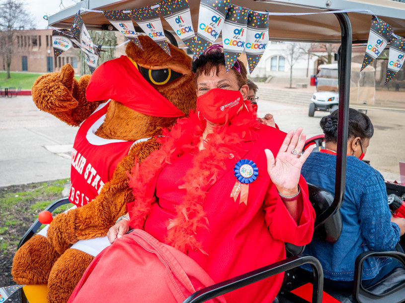 Karen L. Pennington and Rocky the Red Hawk wave at her retirement parade.