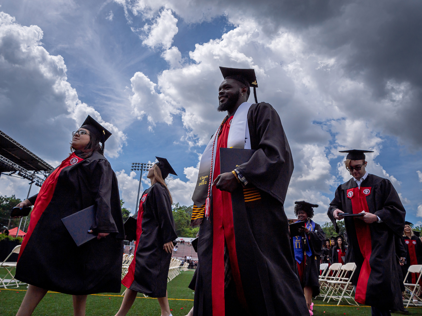 graduates walking on campus in caps and gowns