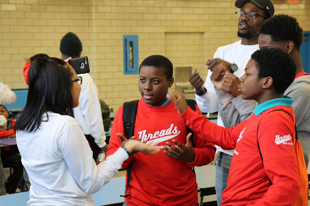 Llyasha Moore and Samueldo Mompoint (in white) talk with boys in the program.
