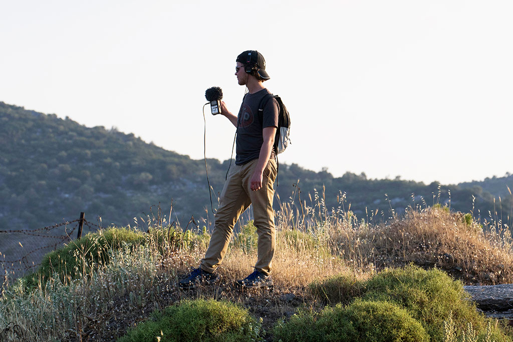 Shawn Latham records audio on a hill overlooking Mytilene.