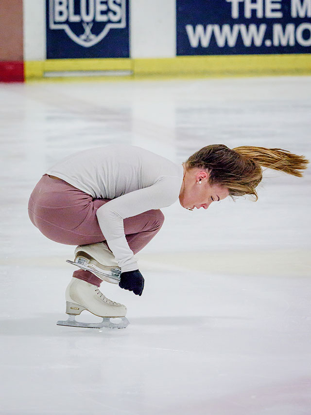Isadora Williams bent over while figure skating.