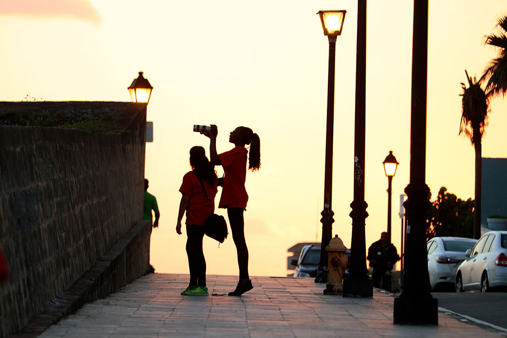 Traore stands on her toes to take a photo at El Morro in Old San Juan, along with Galarza.