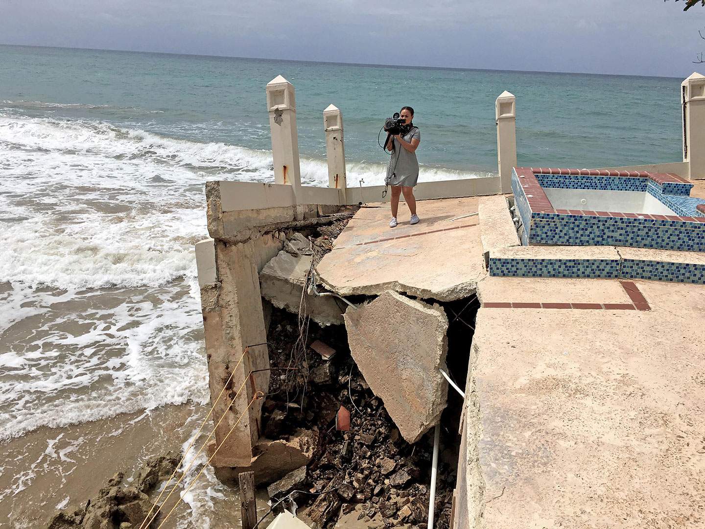 Senior Natalie De La Rosa films storm damage on the pool deck of Tres Sirenas, an oceanfront boutique hotel in Rincón, Puerto Rico.