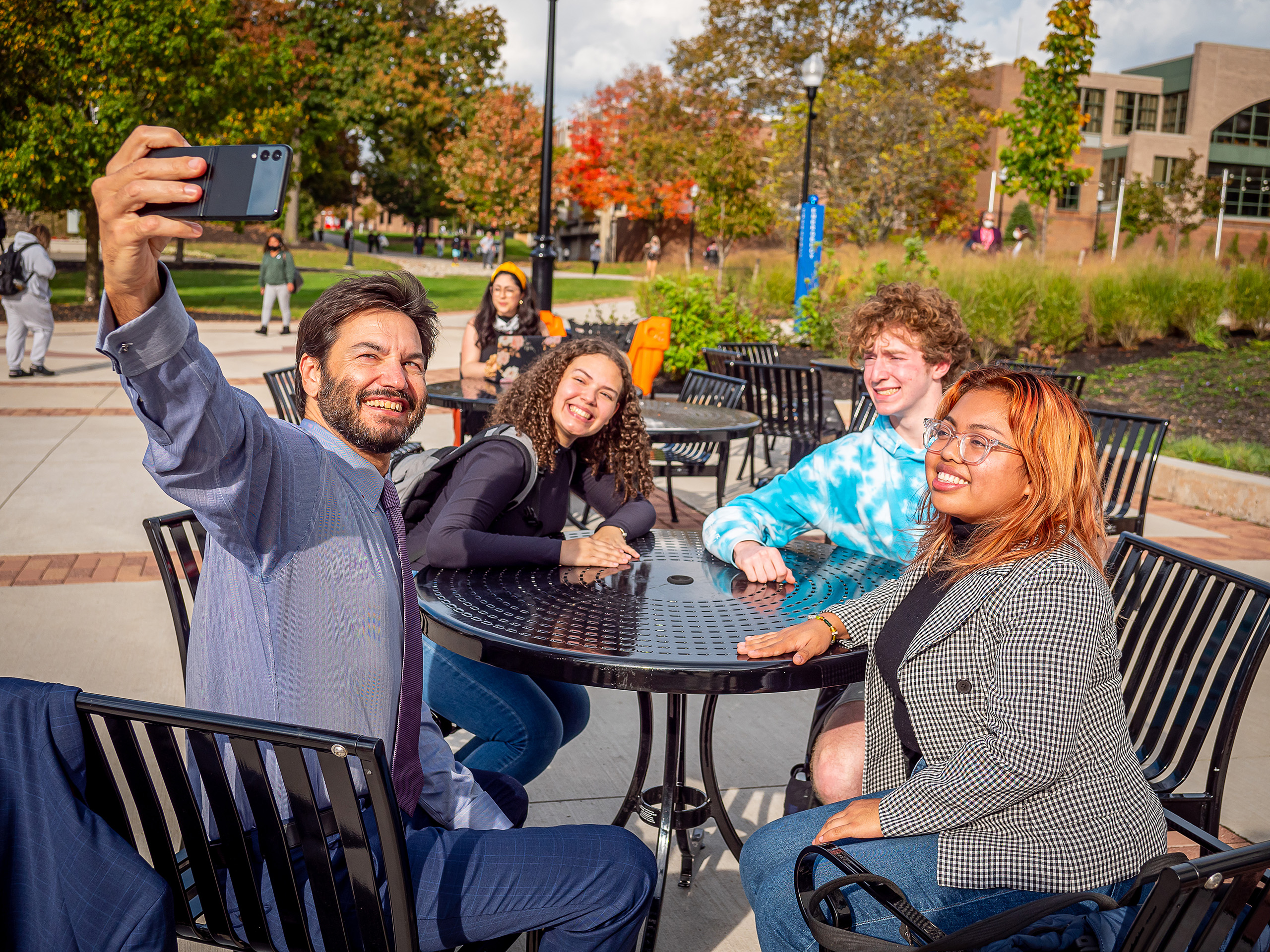 President Koppell taking a selfie with students on campus