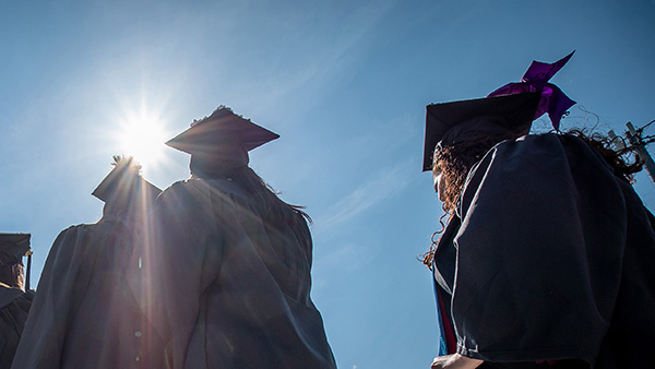 students walking in caps and gowns