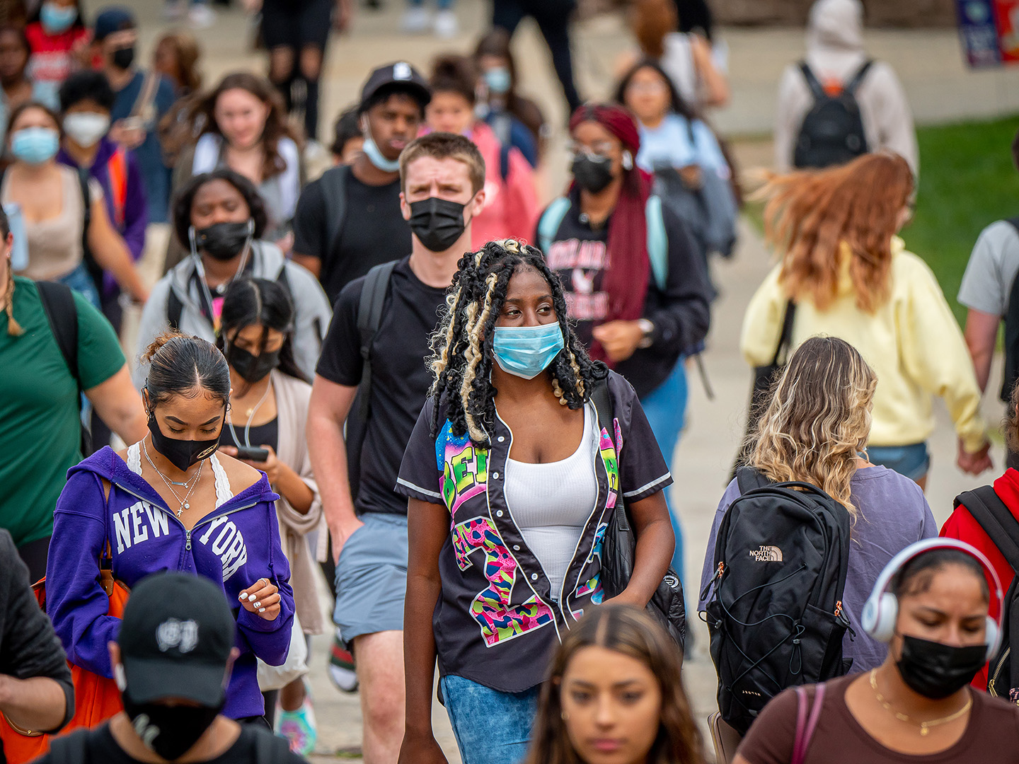 students wearing masks walking on campus