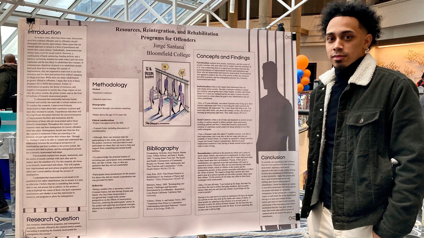 Jorge Santana stands next to poster